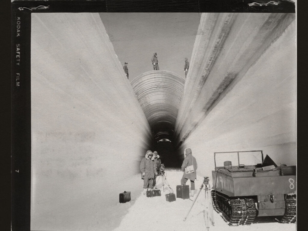 Photographers from the US Army prepare to shoot on Camp Century's "main street" while metal sheets are laid over the tunnel.